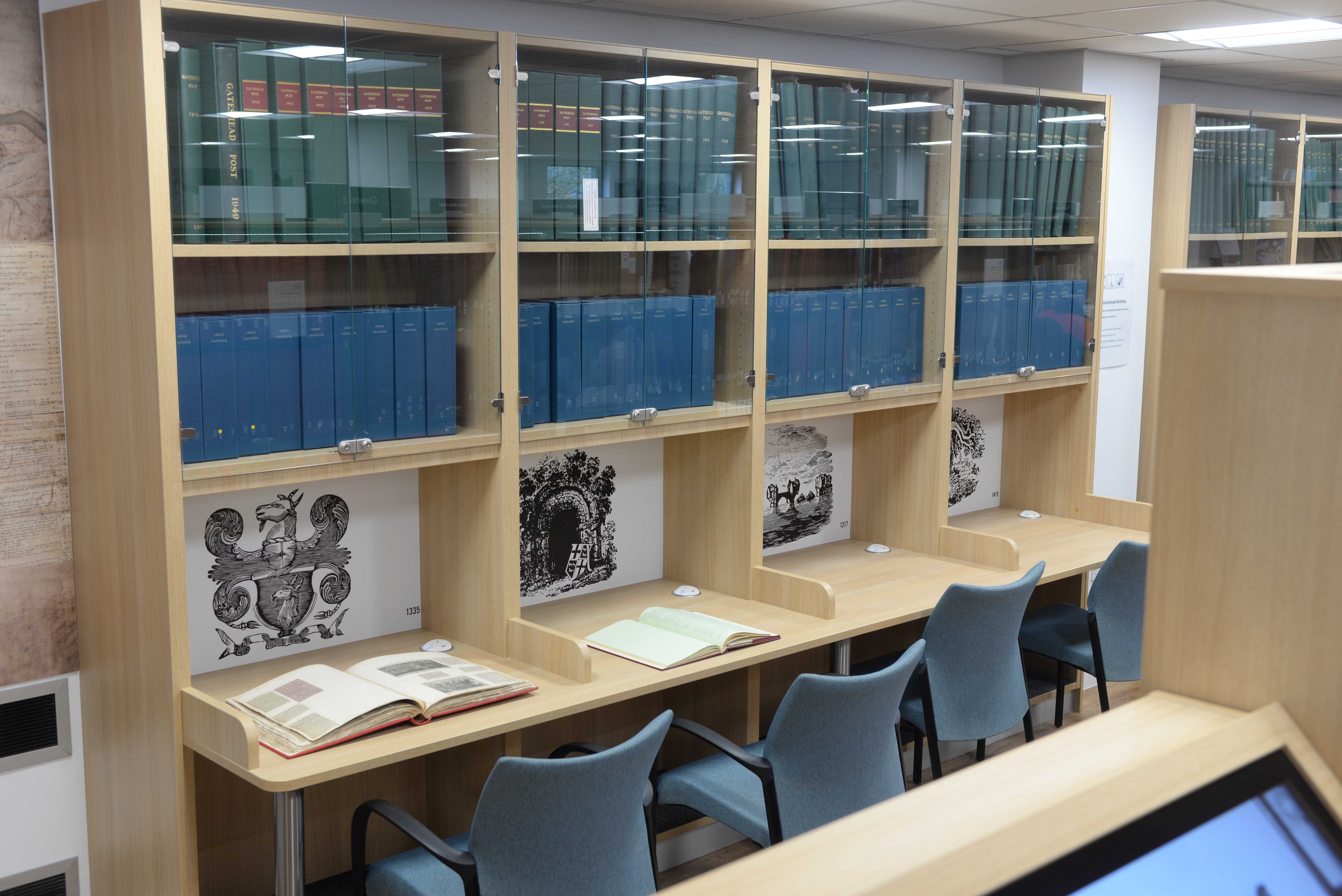 Customised individual study desks with glazed cabinets above for the runs of bound volumes