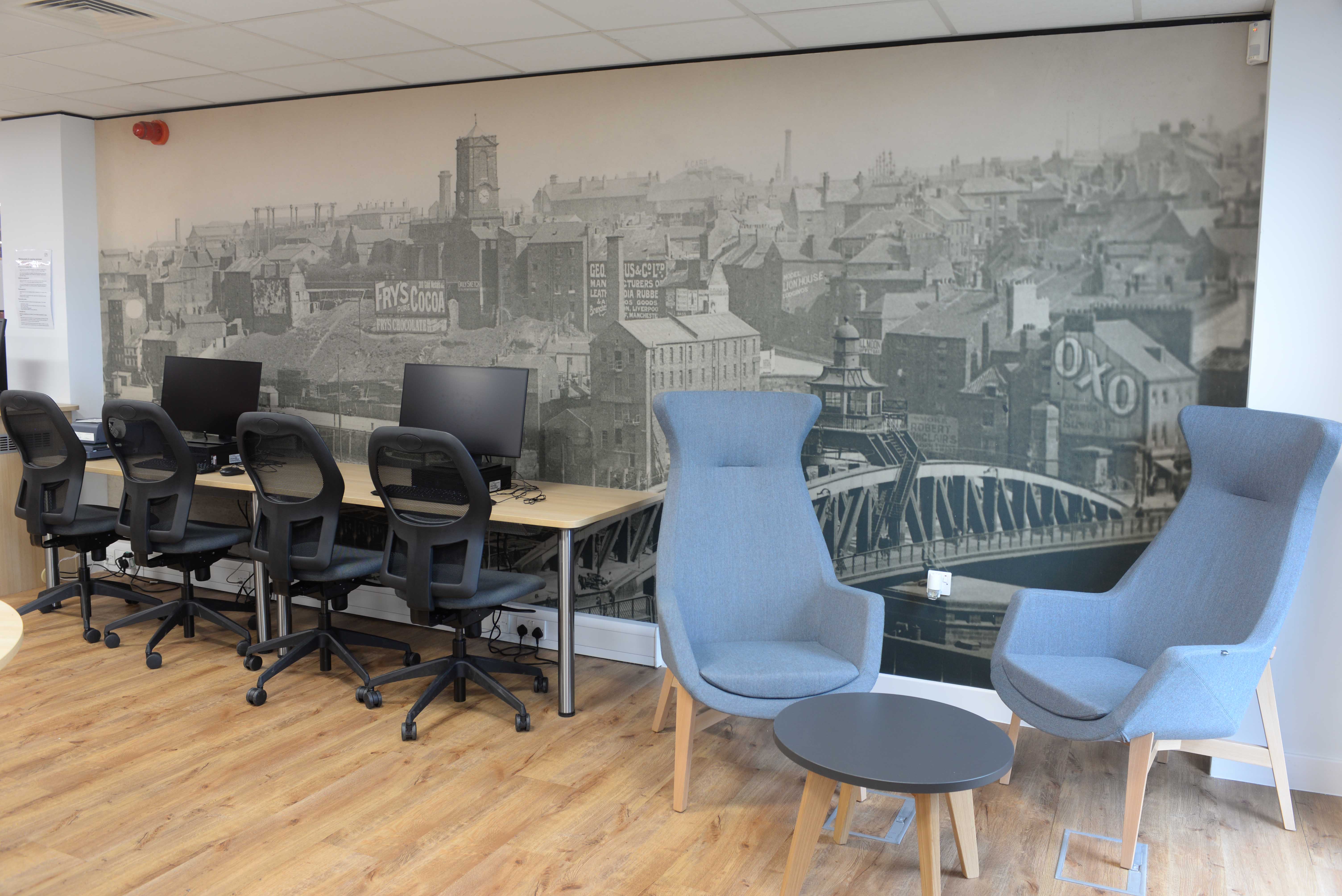 Early archive photo of Gateshead used as wall graphic behind PC desks and seating area